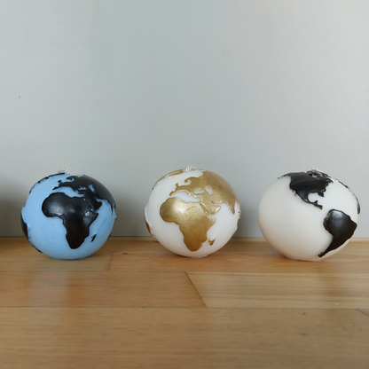Handgegossene Globus-Kerze aus europäischem Rapswachs in vier Farbkombinationen – Weiss/Gold, Blau/Gold, Weiss/Schwarz, Blau/Schwarz, gefertigt im Atelier Romanshorn