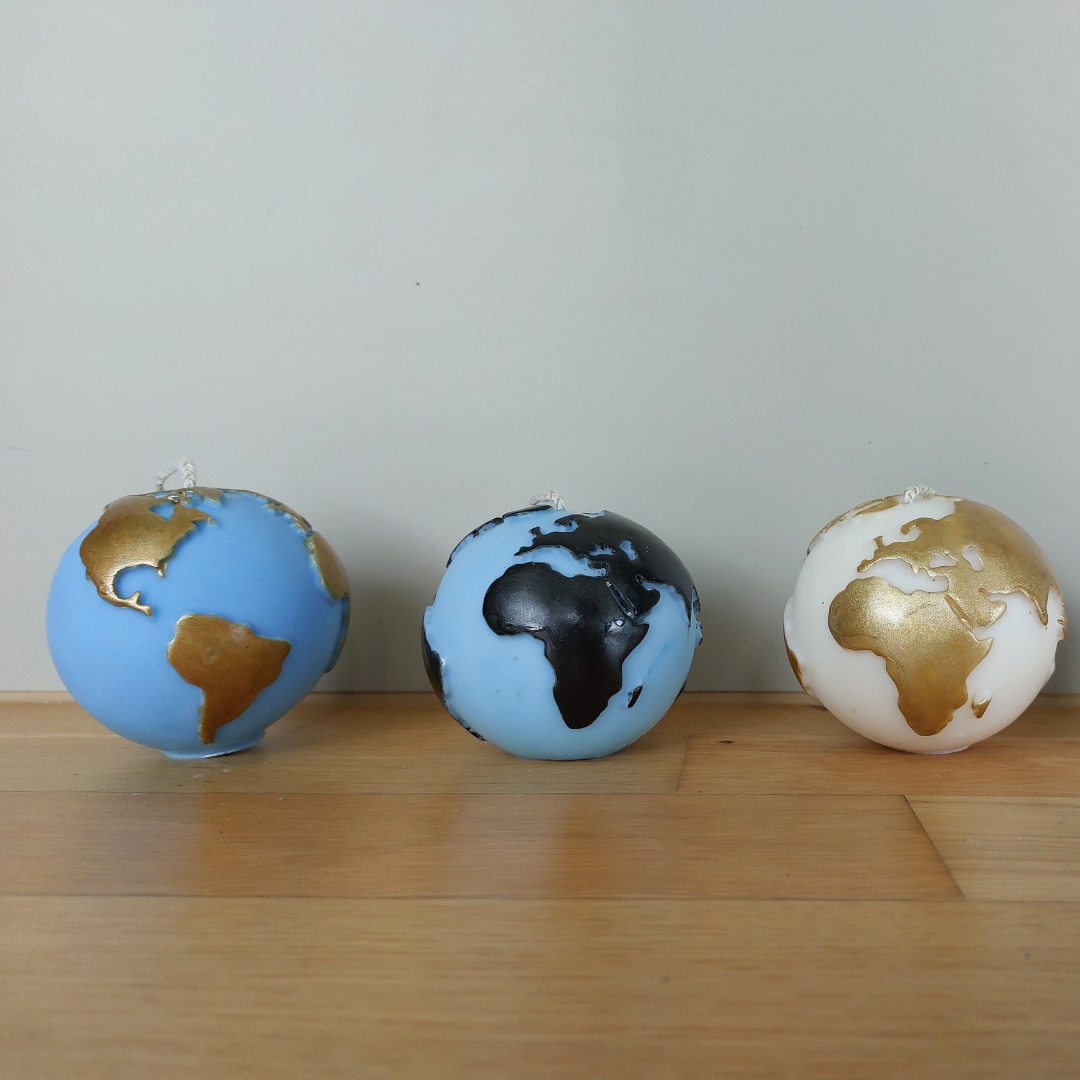 Handgegossene Globus-Kerze aus europäischem Rapswachs in vier Farbkombinationen – Weiss/Gold, Blau/Gold, Weiss/Schwarz, Blau/Schwarz, gefertigt im Atelier Romanshorn